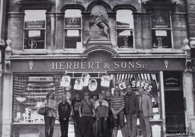 Photoshop image of the 2010 Down our Weigh team standing in front of the Herbert shop as it was in 1889